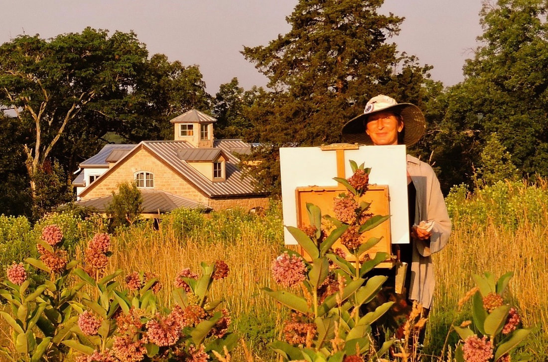 Photo of artist Julie Wiegand painting plein air in her prairie in front of Lyon School Studio & Gallery.